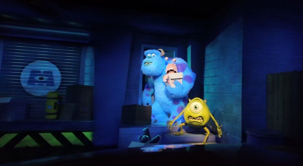 Sulley holds Boo while Mike Wazowski looks panicked in a dark alley scene inside Monsters, Inc. Mike & Sulley to the Rescue! at Disney California Adventure.