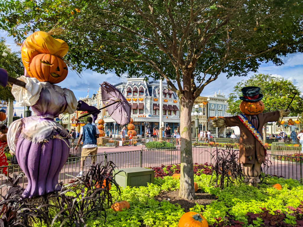 Victorian pumpkin citizens—a lady with a parasol and a gentleman—posed in Town Square gardens for Magic Kingdom Halloween.