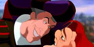 Judge Claude Frollo leans close to Quasimodo’s face, smiling coldly while gripping his chin inside Notre Dame.
