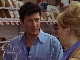 Dimitri speaking in a brightly lit grocery aisle in “Mom’s Got a Date with a Vampire,” casual charm before the fangs come out.