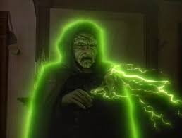 “Mr. Boogedy” still—a hooded ghost outlined in neon green crackles with energy, hand raised as eerie light shoots from his fingers.