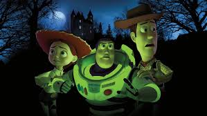 “Toy Story of Terror!” still—Jessie, Buzz, and Woody glow green under moonlight in a spooky forest, a haunted house silhouette on the hill behind them.